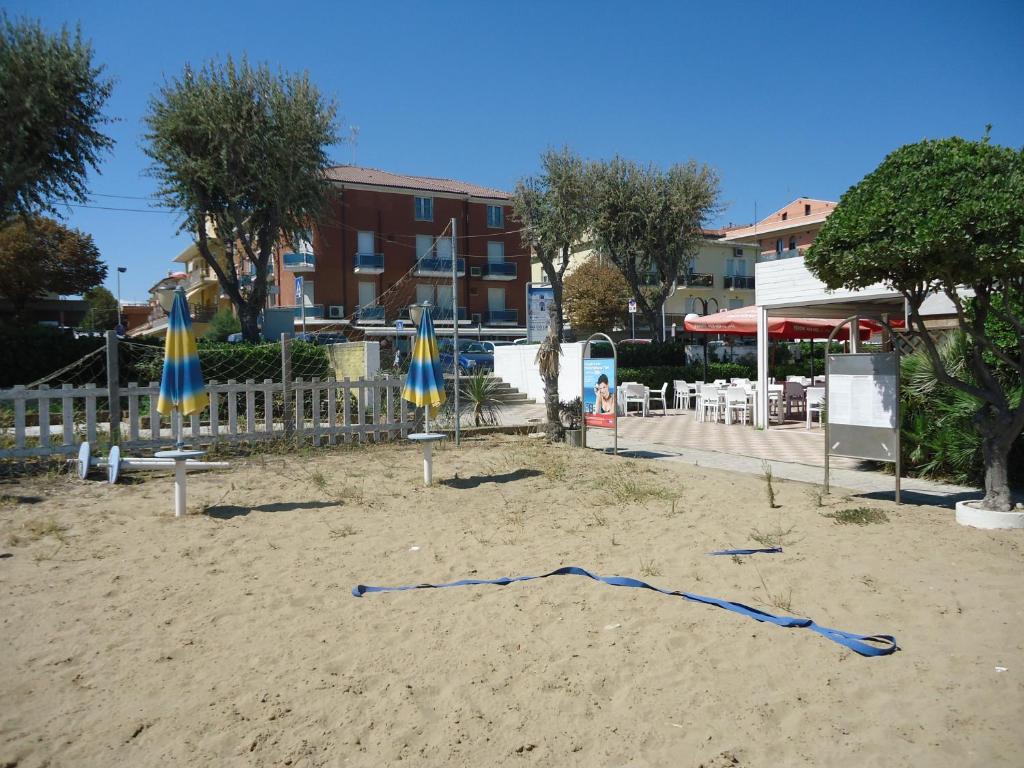 una playa con sombrillas y una cuerda azul en la arena en Hotel L&V, en Rímini