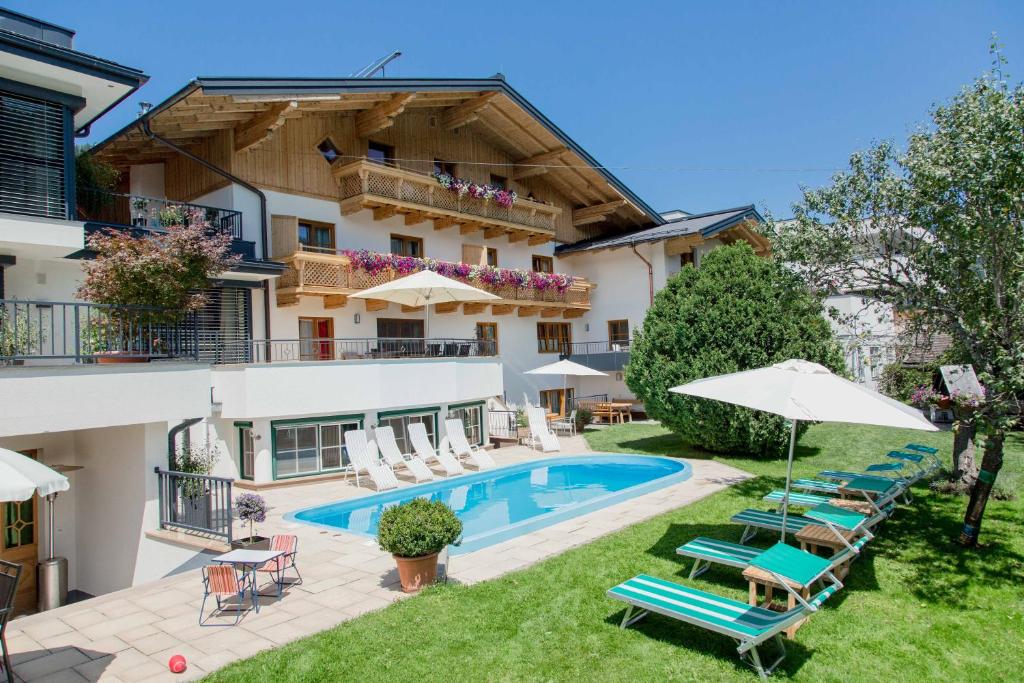 a hotel with a swimming pool and patio furniture at Aparthotel Steger Wagrain in Wagrain