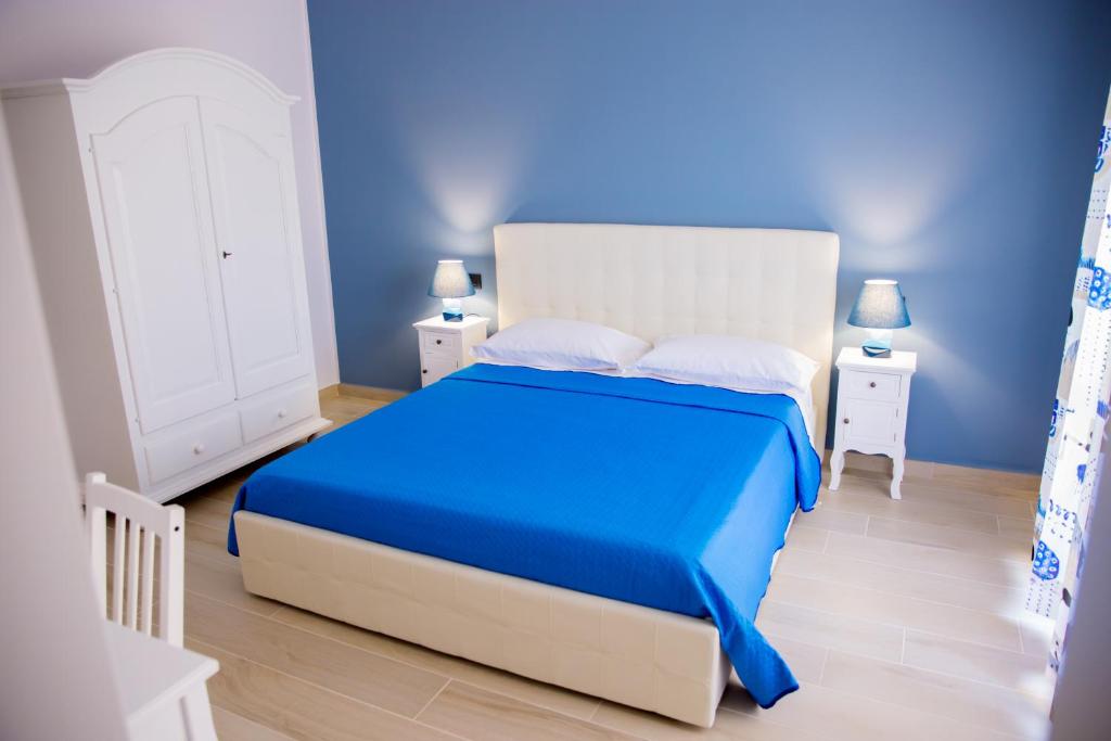 een blauwe slaapkamer met een bed en twee nachtkastjes bij Gleda Rooms in Pompei