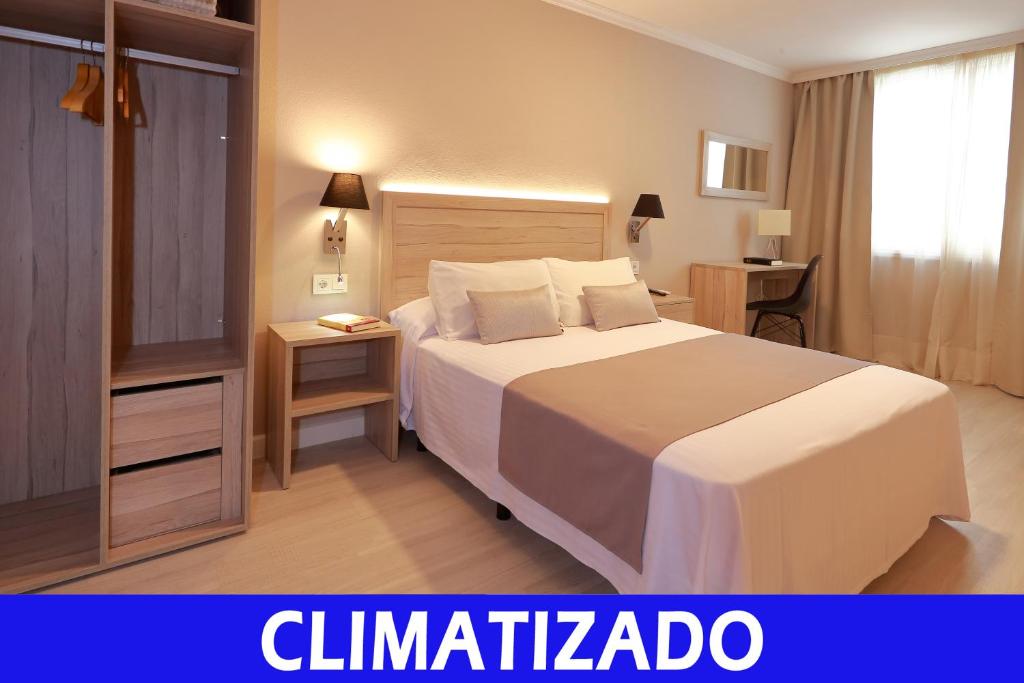 um quarto de hotel com uma cama e uma televisão em Hotel Villa de Verín em Verín
