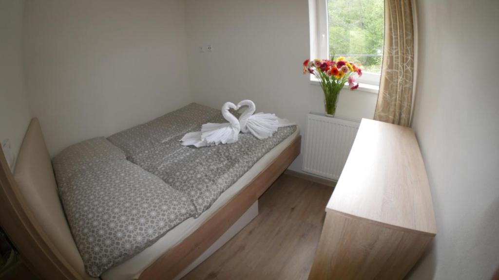 łóżko z białym łukiem w pokoju w obiekcie Všemina Apartman w mieście Lužkovice