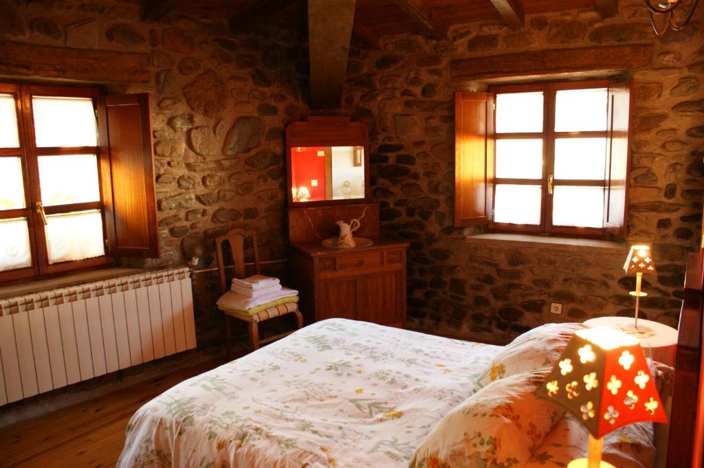 sypialnia z łóżkiem, lustrem i oknami w obiekcie Casa Rural Ugarte Ojacastro w mieście Ojacastro
