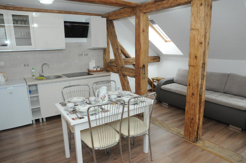 Il comprend une cuisine et un salon avec une table et des chaises. dans l'établissement Apartamenty Kamienica, à Mrągowo
