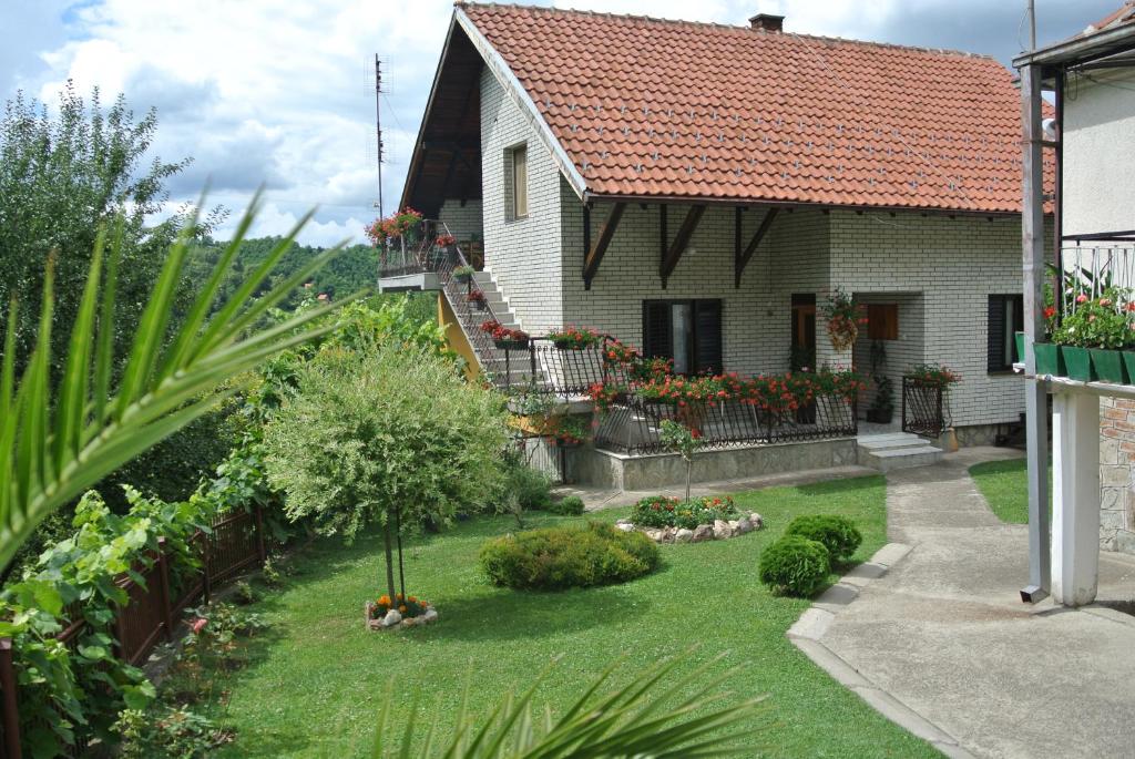 a house with a yard with flowers and plants at Apartmani Mali Raj Rudnik in Rudnik