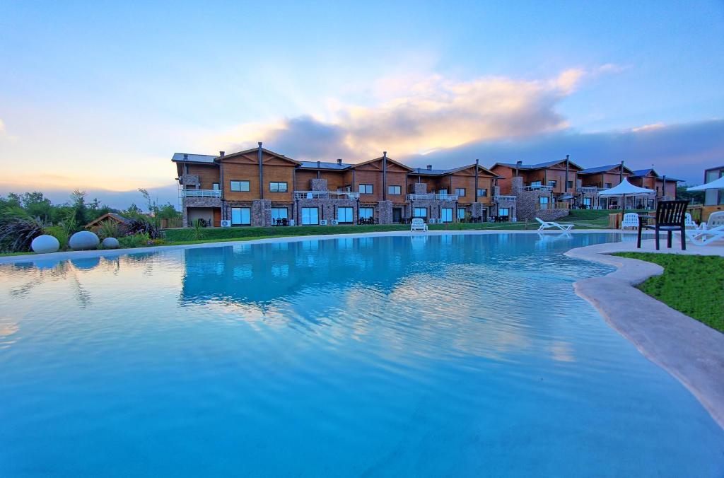 a large swimming pool in front of a apartment complex at Blackstone Country Villages Hotel in Villa General Belgrano