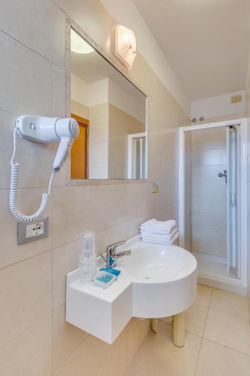 a bathroom with a white sink and a mirror at Hotel Ambassador in Caorle