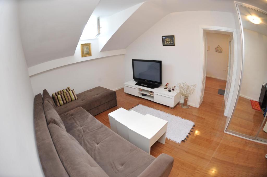 a living room with a couch and a tv at Main Street Apartment in Sarajevo