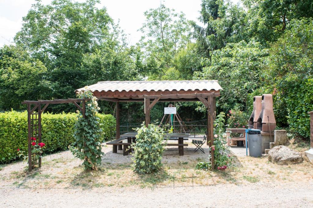 a picnic shelter with a picnic table and a grill at Camping le Mas Fleuri in Sospel