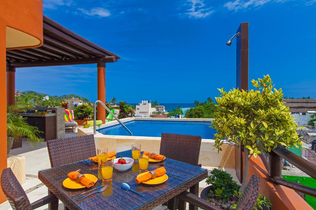 una mesa con comida y bebida en la parte superior de un balcón en Beach Break Suites Sayulita en Sayulita