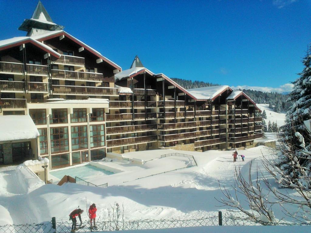 um grande hotel na neve com pessoas em frente em Les Terrasses Du Mont Blanc em Le Praz de Lys