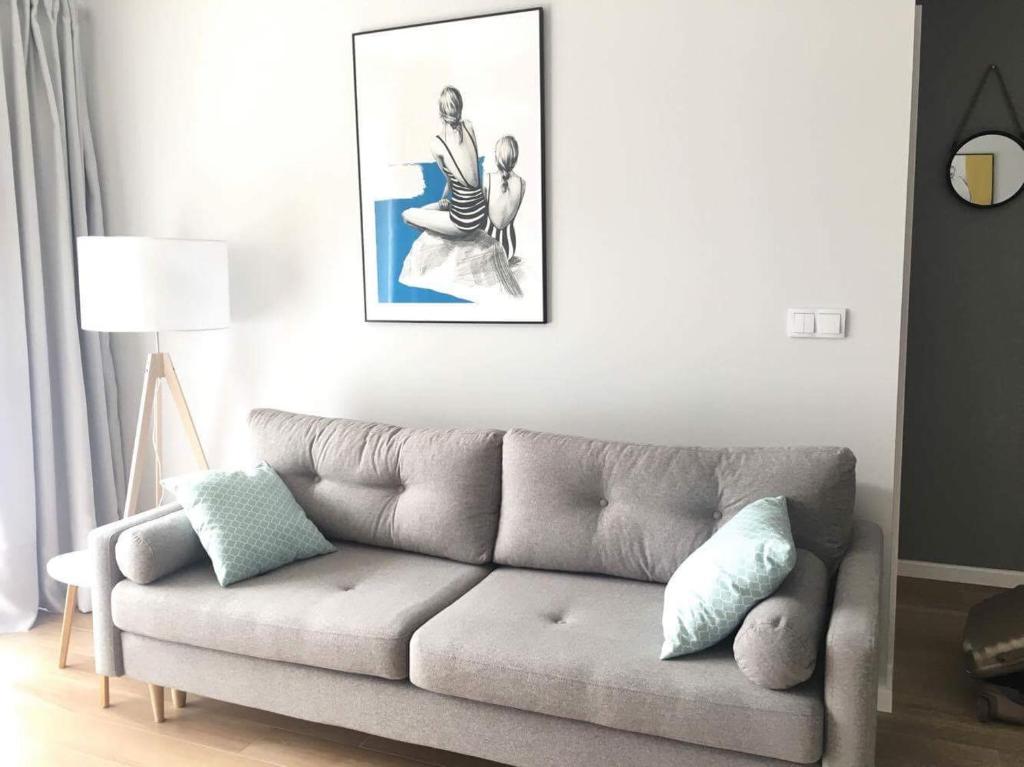 a living room with a couch and a picture on the wall at Apartament Słoneczny Dwie Sosny in Ustronie Morskie