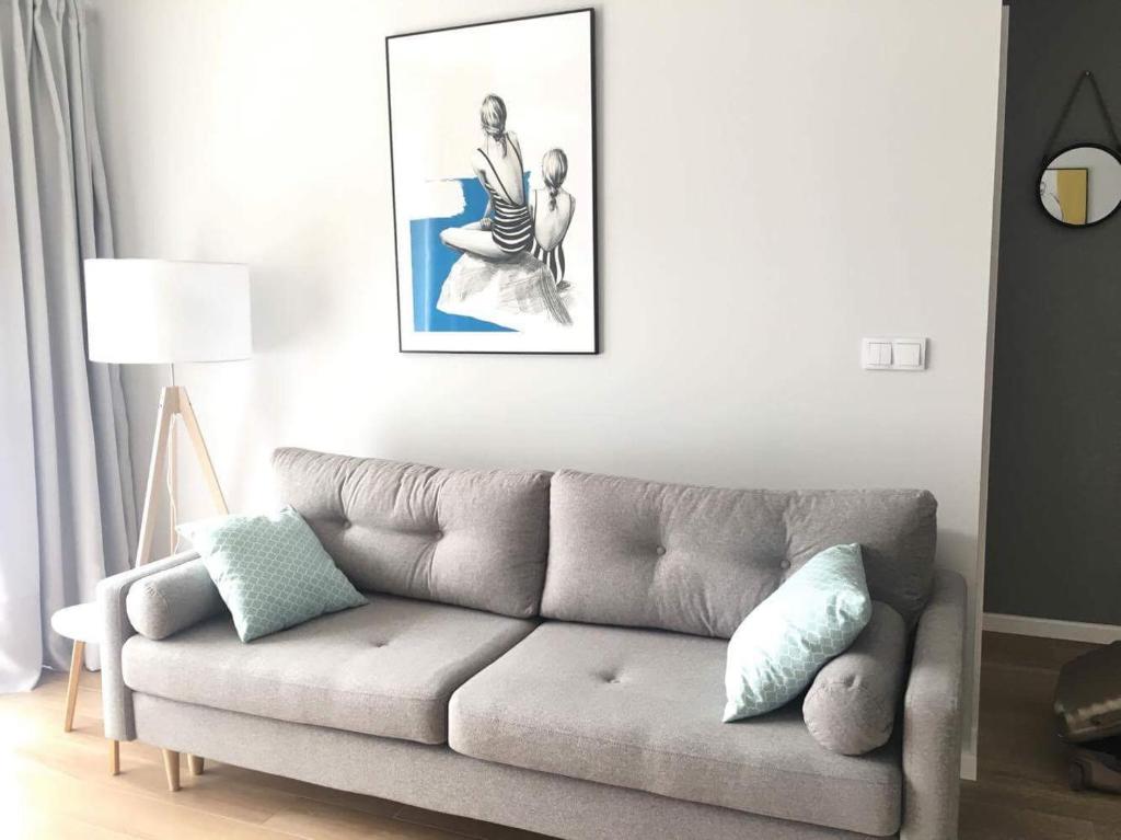 salon z kanapą i zdjęciem na ścianie w obiekcie Apartament Słoneczny Dwie Sosny w mieście Ustronie Morskie