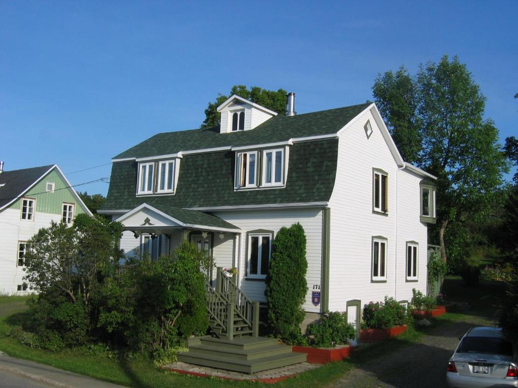 uma grande casa branca com um telhado verde em Maison du Photographe em Bic