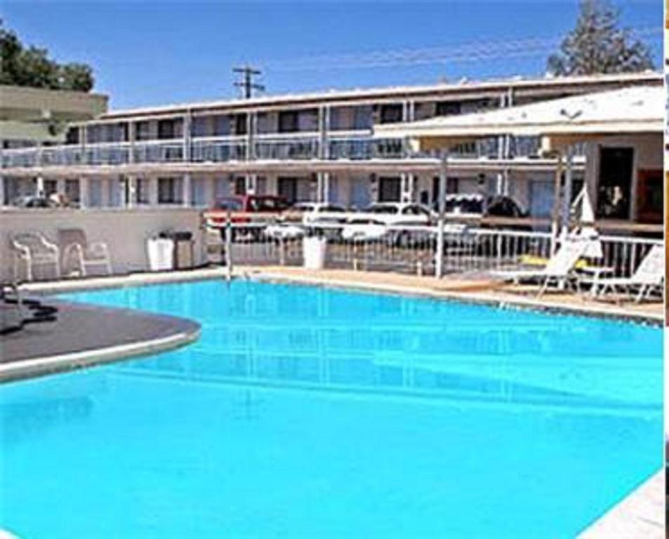 una gran piscina azul frente a un hotel en Winnemucca Holiday Motel, en Winnemucca