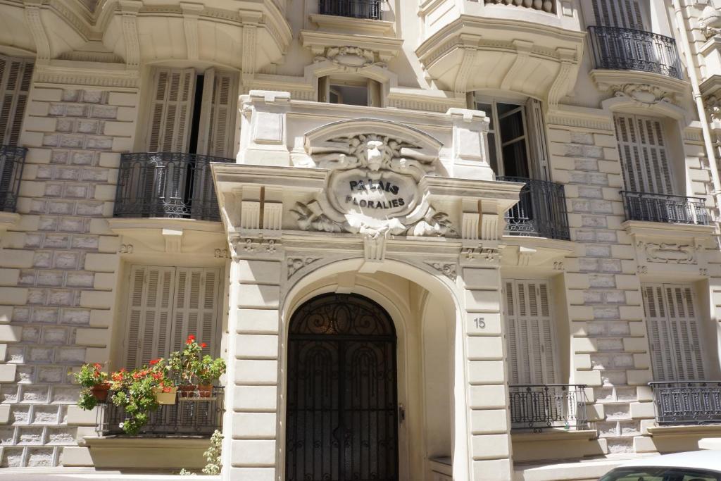 - un grand bâtiment blanc avec une porte et des fleurs dans l'établissement Adorable apartment in Nice downtown, à Nice