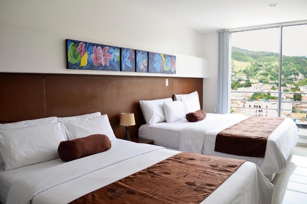 Кровать или кровати в номере Hotel Tarigua Ocaña