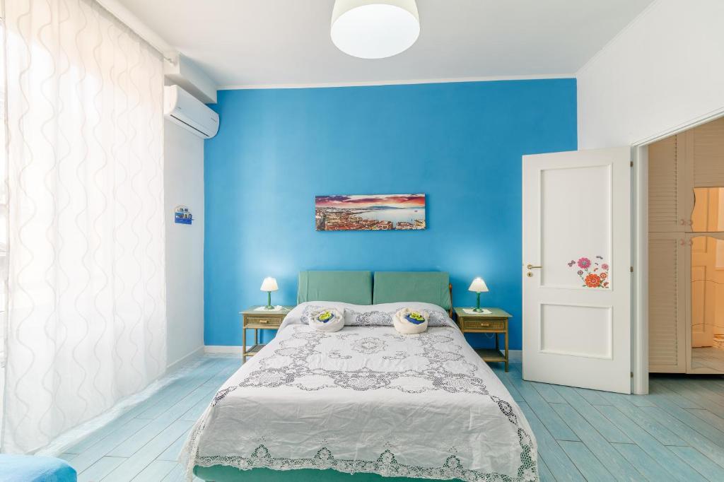 Dormitorio azul con cama y pared azul en Casa Lego Napoli, en Nápoles