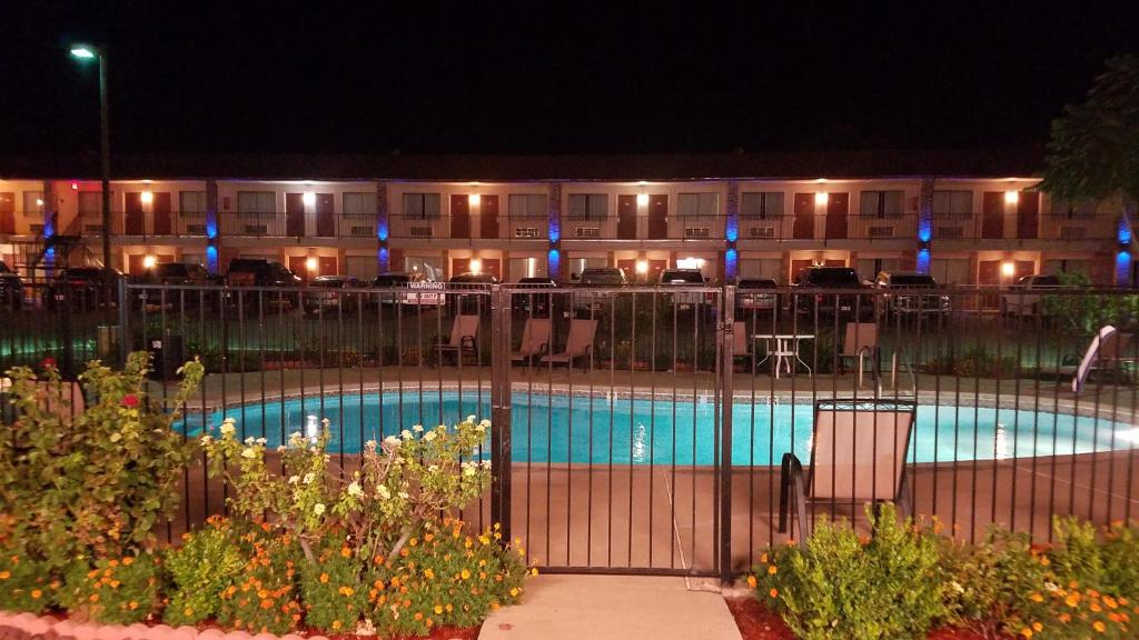 a swimming pool in front of a hotel at night at Shiloh Inn Lamesa in Lamesa