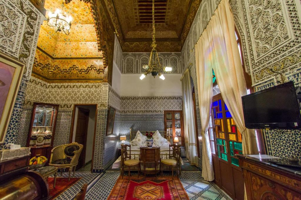 a living room filled with furniture and a large window at Riad Damia in Fez