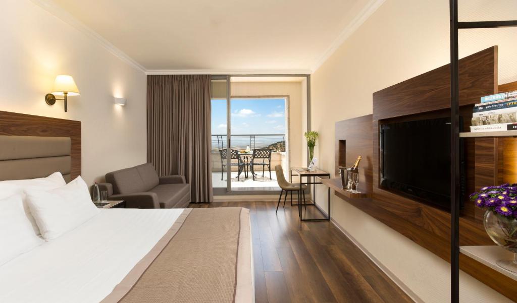 a hotel room with a bed and a television at Golden Crown Hotel in Nazareth