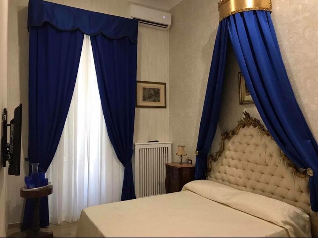 ナポリにあるRoyal Gismondaのベッドルーム(青いカーテン付きのベッド1台付)
