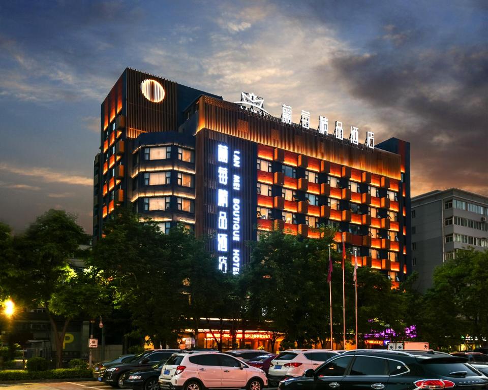 ein Gebäude mit davor geparkt in der Unterkunft Lanmei Boutique Hotel West Station Branch Lanzhou (Lanzhou City Center Branch) in Lanzhou