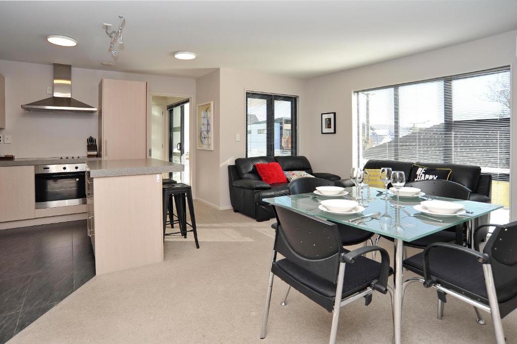 una cucina e un soggiorno con tavolo e sedie di Carlton Villa 3 - Christchurch Holiday Homes a Christchurch