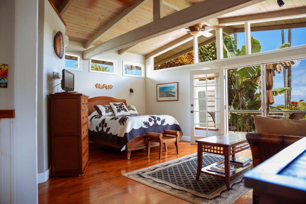 a bedroom with a bed in a room with windows at Orchid Tree B&B in Hilo