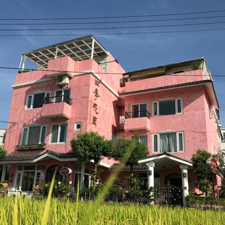 冬山鄉的住宿－四季花園民宿 宜蘭羅東民宿，粉红色砖砌建筑,设有大屋顶