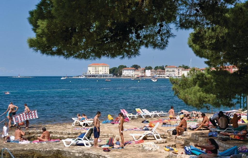 a group of people sitting on a beach at Apartments Residence by Tourist in Poreč