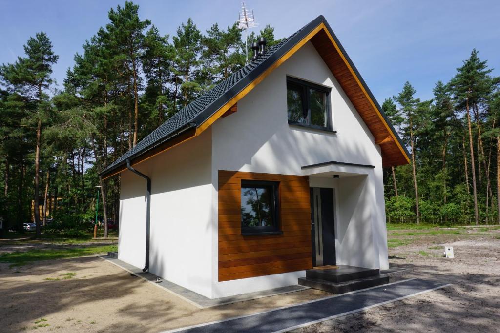 ポゴジェリツァにあるBłękitna Falaの黒屋根の小さな白い家