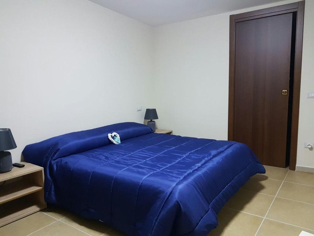 niebieskie łóżko z niebieską pościelą w sypialni w obiekcie Fiore di Loto w mieście Limatola