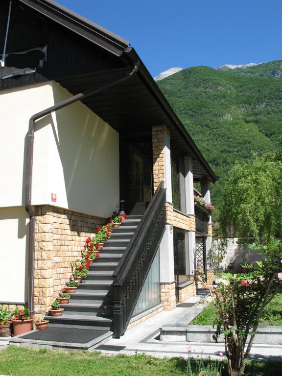 a house with stairs and flowers on the side at Apartment Mars in Bovec
