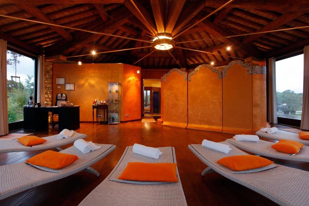 ein Zimmer mit einem Haufen Betten mit orangefarbenen Kissen in der Unterkunft Bio Agriturismo La Bell'Antiglia in Montemerano