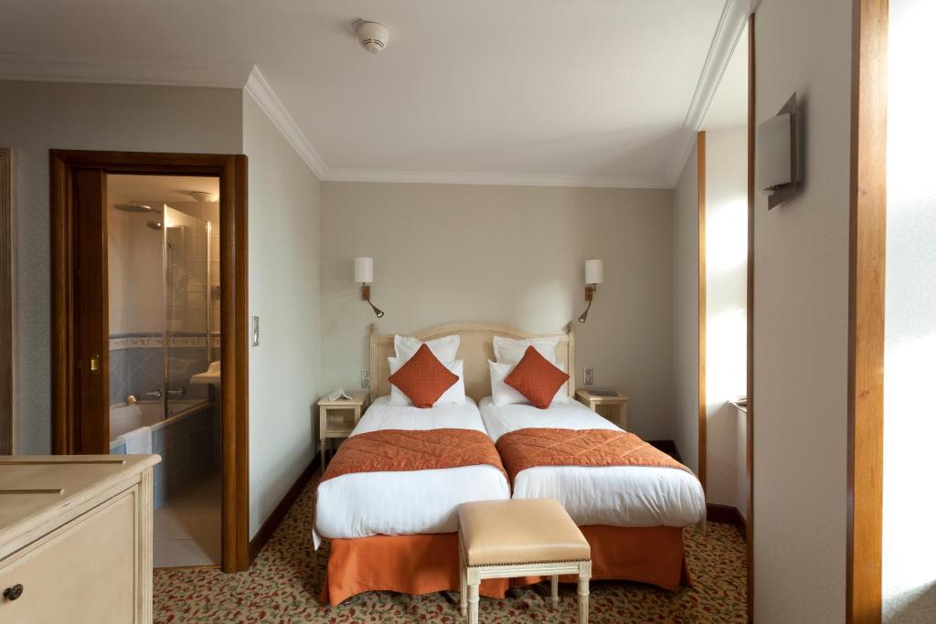 a hotel room with a large bed and a bathroom at Auberge Saint Pierre in Le Mont Saint Michel