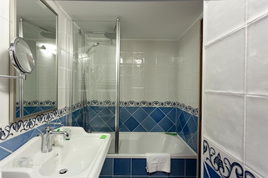 a bathroom with a tub and a sink and a mirror at Auberge Saint Pierre in Le Mont Saint Michel