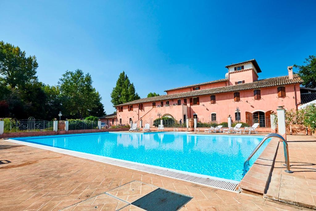 a large swimming pool in front of a building at Agriturismo Il Molino Antico in Uncinano