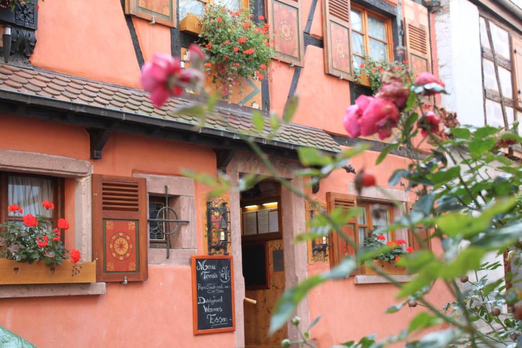 un edificio rosa con dei fiori di fronte di Studio Ulysse a Zellenberg