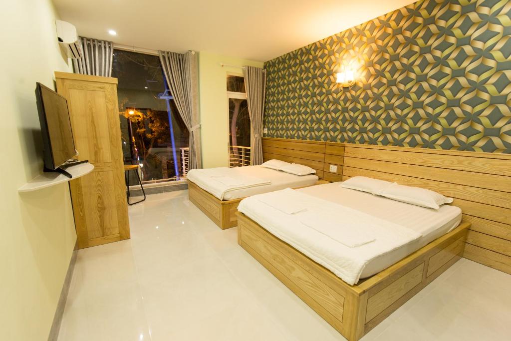 Pokój z dwoma łóżkami i telewizorem w obiekcie Thuan Hoa Hotel w mieście Vung Tau