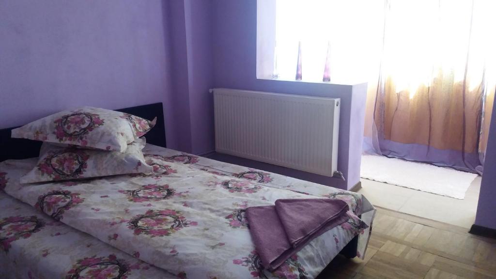 ルムニク・ヴルチャにあるApartament Valcea Centralのベッドルーム1室(花の咲く毛布と枕付きのベッド1台付)