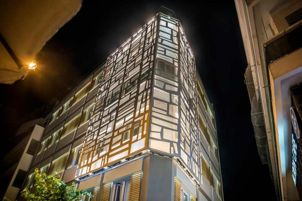 a building with a lit up facade at night at AD Athens Luxury Rooms & Suites in Athens