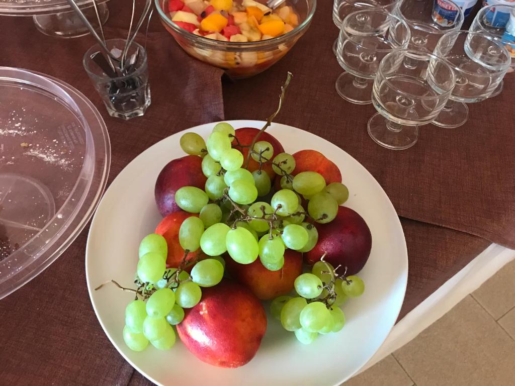 a plate of fruit on a wooden table at Rosy And Roby in Gasponi