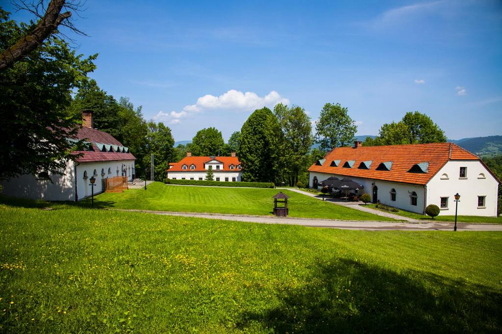 grupa budynków na polu z zieloną trawą w obiekcie Dwor Rychwald w mieście Rychwałd
