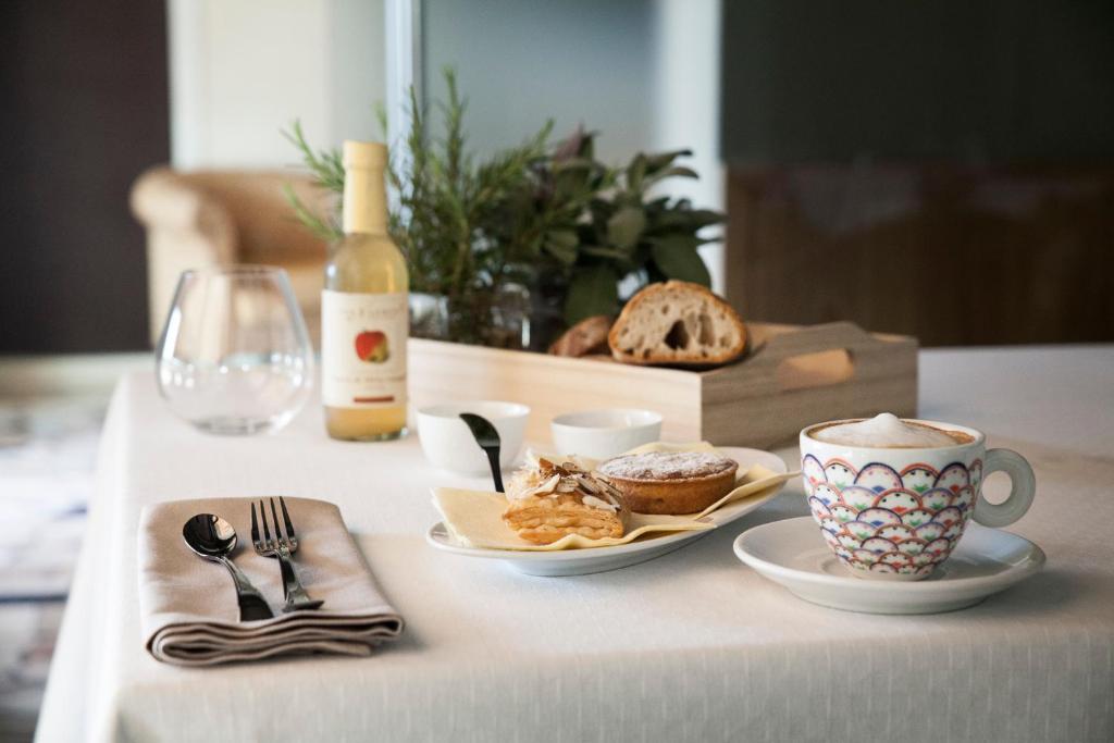 un tavolo con un piatto di cibo e una bottiglia di vino di Hotel Trieste a Pontelongo