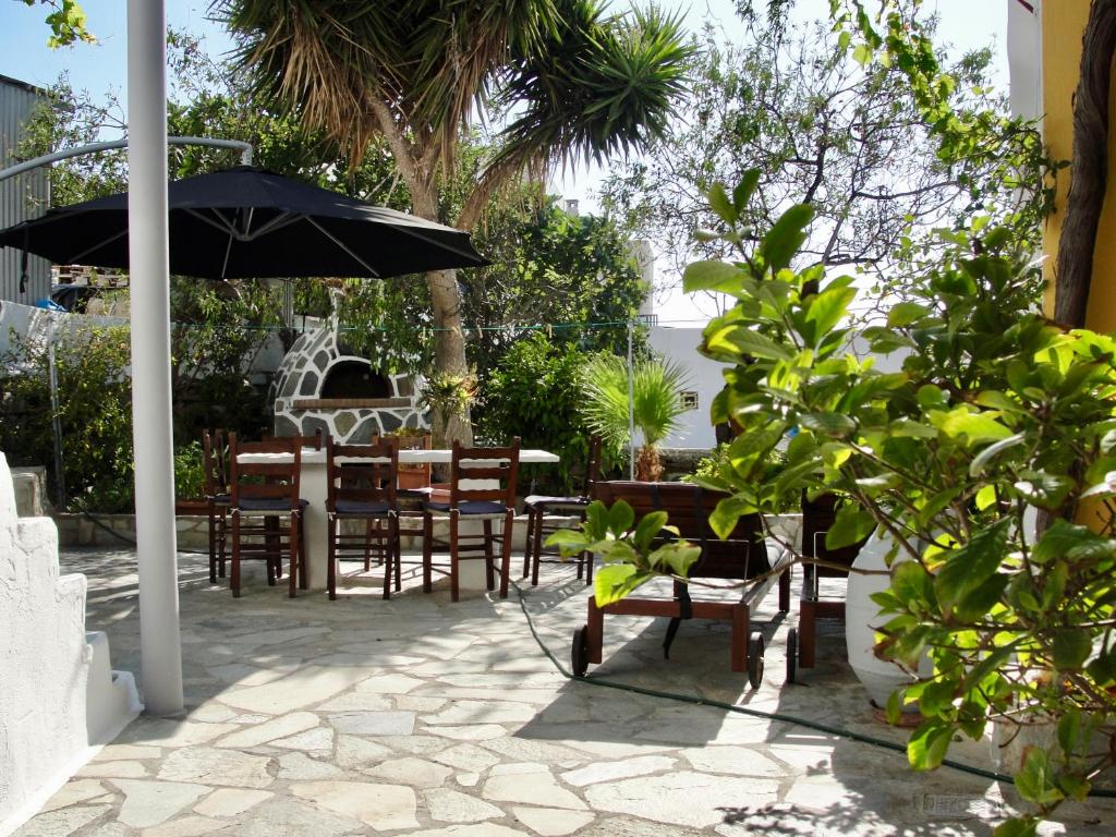 イオス島 チョーラにあるAvli Studios & Apartmentsのパティオ(テーブル、椅子、パラソル付)