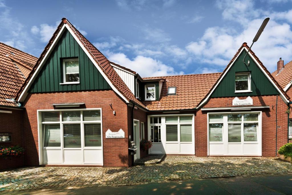 a brick house with a green roof at Pension Alte Feuerwehr in Schüttorf