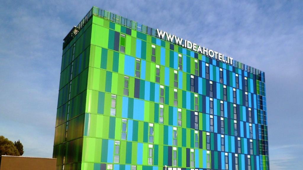 a green and blue building with a sign on it at Idea Hotel Plus Savona in Savona