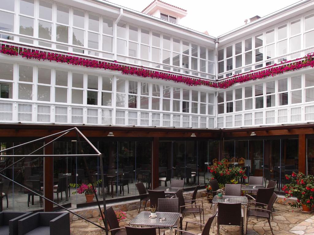 a large white building with tables and chairs at El Montero in Soto