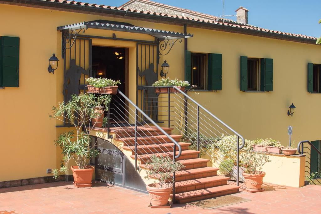 uma casa com escadas e vasos de plantas em Agriturismo Podere Villa Alessi em Cinto Euganeo