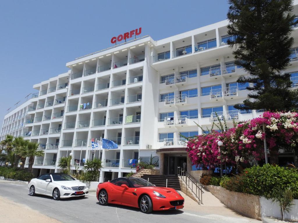 two cars parked in front of a hotel at Corfu Hotel in Ayia Napa